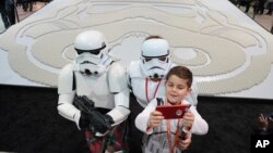 Penggemar berat Star Wars, Joseph Naiman, 7, berswafoto bersama orang tuanya Marshall (kiri), dan Danielle di sebelah peragaan figur mini LEGO Star Wars terbesar pada Perayaan Star Wars, 11 April 2019 di Chicago (foto: Alex Garcia/AP Images untuk the LEGO Group)