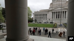 People gather outside the Temple of Justice and in front of the Legislative Building, Thursday, April 23, 2020, at the Capitol in Olympia, Wash., as Washington state Supreme Court justices were hearing oral arguments inside — but using remote video…