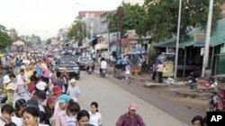 Cambodian garment factory workers wait for the ride in front of their factory to go home in Phnom Penh, Cambodia. 