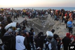 On binlerce Filistinli Akdeniz kıyısından Gazze'nin kuzeyine yürüyor.