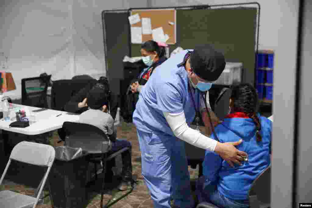 Una joven migrante pasa por un chequeo m&#233;dico antes de entrar al &#225;rea de admisi&#243;n. 