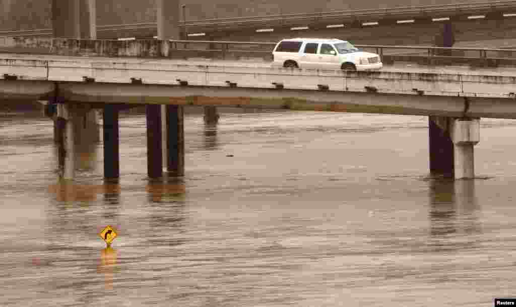 A SUV drives over flooded White Oak Bayou in Houston, Texas, USA, Oct. 25, 2015. Precipitation was expected to intensify over the weekend as moisture from tropical depression Patricia, which struck the Pacific coast of Mexico as a very powerful hurricane, meets with a storm system coming from the west and over Texas.