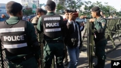 FILE - Riot police stand guard at a blocked street outside the supreme court in Phnom Penh, Cambodia, Nov. 16, 2017. The court ultimately dissolved the opposition Cambodia National Rescue Party, seen as another move by authoritarian Prime Minister Hun Sen to remove threats to his power ahead of elections next year.