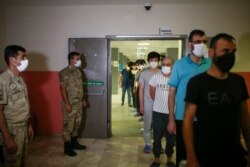 Migrants, mainly coming from Afghanistan, walk at a deportation center in Van, Turkey, that borders Iran, Aug. 23, 2021.