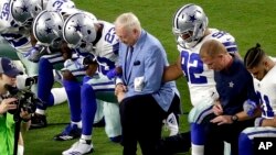 Para pemain klub NFL Dallas Cowboys, dan pemilik klub Jerry Jones, berlutut sebelum pertandingan melawan klub Arizona Cardinals, di Glendale, Arizona, Senin malam (25/9). 