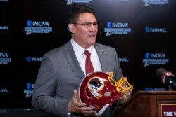 Washington Redskins head coach Ron Rivera holds up a helmet during a news conference at the team's NFL football training facility in Ashburn, Virginia, Jan. 2, 2020.
