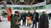 A man takes a selfie with people holding a portrait of slain Hezbollah leader Hassan Nasrallah before boarding a flight to Beirut at the Baghdad International Airport on Feb. 20, 2025. Thousands of Nasrallah's supporters are traveling to Lebanon for his funeral on Feb. 23.