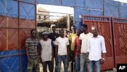 Elhadji Moctar Gueye (far right) with his team of employees outside his metallic workshop in Dakar, December 19, 2011.