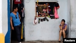 Vendors await customers at their private imported clothing outlet, Havana, Oct. 5, 2013.