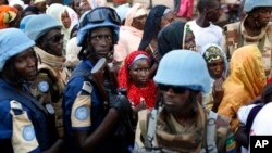 FILE- In this Nov. 30, 2015 file photo, UN soldiers stand near Muslims faithful queuing to enter the Central Mosque on the occasion of Pope Francis' visit, in Bangui's Muslim enclave of PK5, Central African Republic.