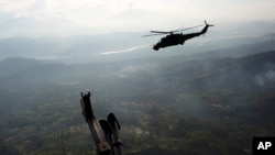 FILE - A military helicopter flies over the VRAEM region, in Pichari, Peru, Sept. 19, 2014. The region in the Apurimac, Ene and Mantaro river valleys, or VRAEM, is the world's No. 1 coca-growing region.