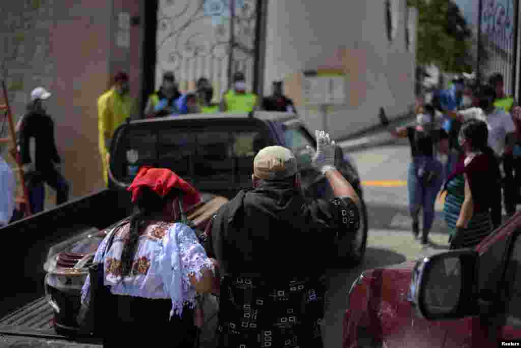 Los dolientes dan el último adiós a su ser querido, mientras una camioneta con el ataúd ingresa a un cementerio.&nbsp;