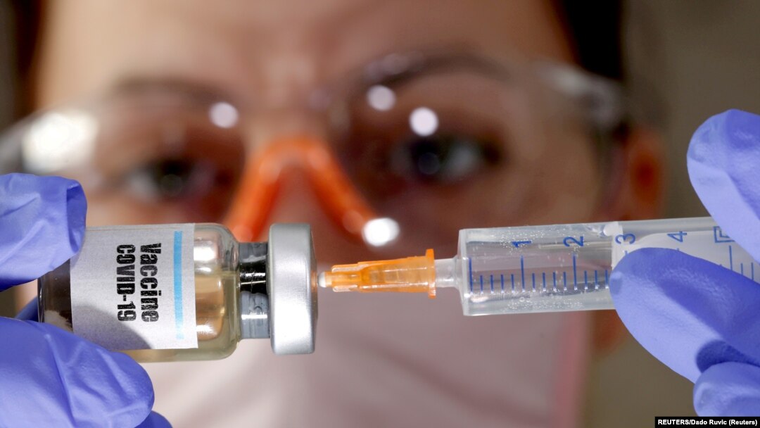 FILE PHOTO: A woman holds a small bottle labeled with a "Vaccine COVID-19"