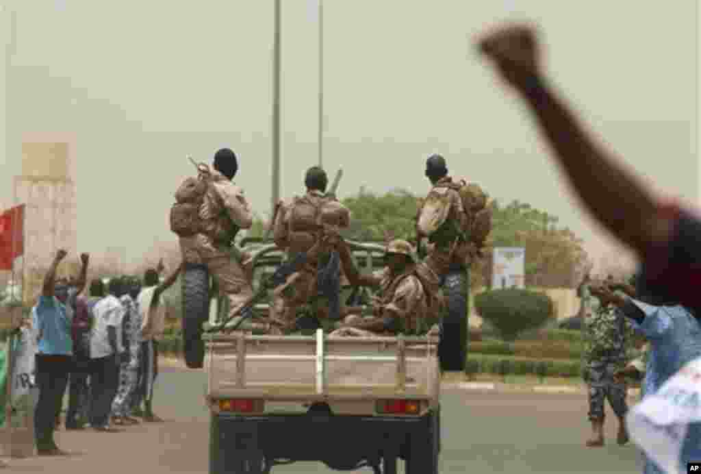 People supporting the recent military coup cheer as the convoy of coup leader Capt. Amadou Haya Sanogo leaves the airport in Bamako, Mali Thursday, March 29, 2012.