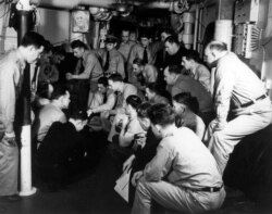 FILE - Naval officers listen to a radio broadcast of President Franklin D. Roosevelt's address to the Congress requesting a declaration of War against the Axis powers, Dec. 8, 1941.