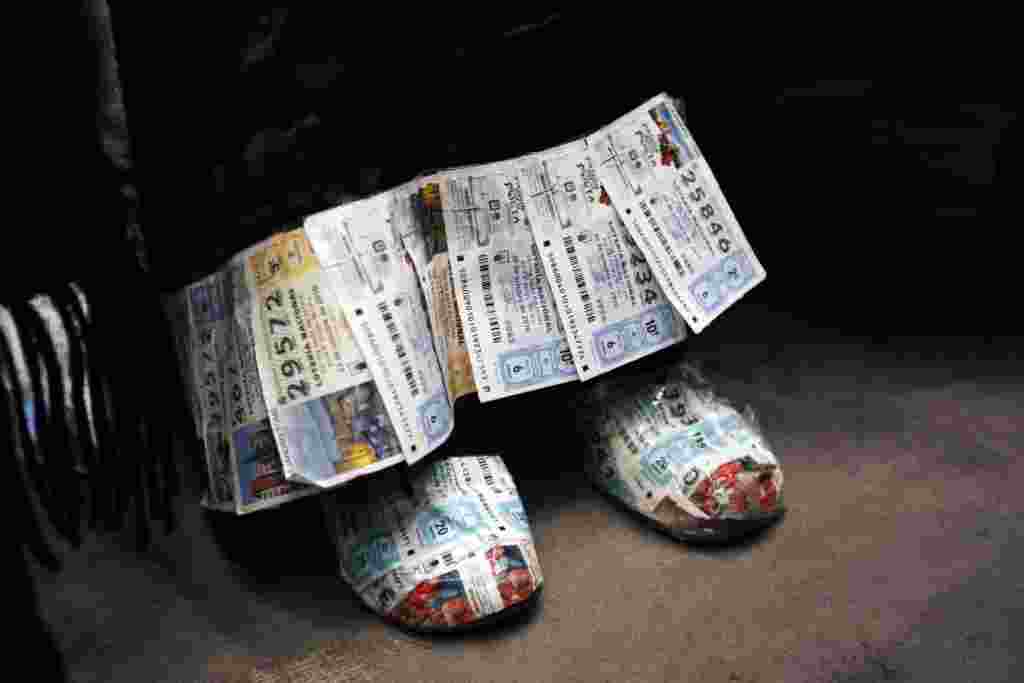 Una mujer veste con unos zapatos y un vestido adornado con billetes de “El Gordo”, una lotería que se juega en la Navidad en Madrid, España. El premio total es de $3.290 millones de dólares.