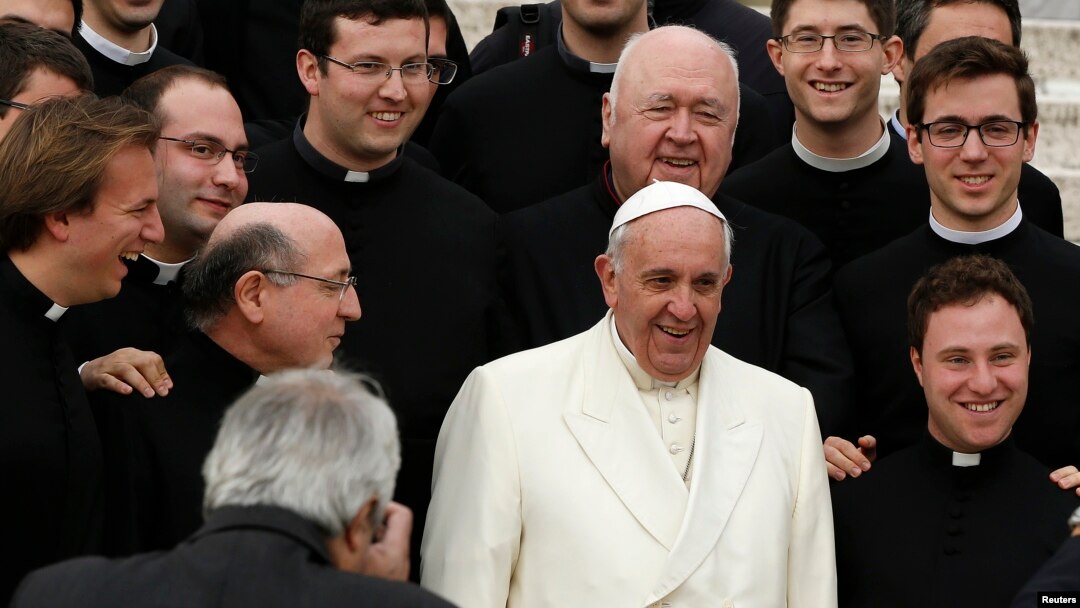 Pope Francis poses with a group of priests at the end his Wednesday general audience in Saint Peter's square at the Vatican Feb. 26, 2014.