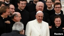 Pope Francis poses with a group of priests at the end his Wednesday general audience in Saint Peter's square at the Vatican Feb. 26, 2014.