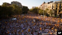 FILE - People wave "estelada" flags, that symbolize Catalonia's independence, during a demonstration calling for the independence of Catalonia, in Barcelona, Spain, Sept. 11, 2016. 