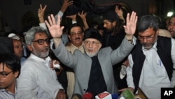 Pakistani cleric Tahir-ul-Qadri waves to his supporters after reaching Lahore, Pakistan, Monday, June 23, 2014. 