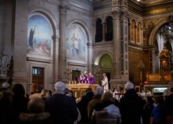 Seorang pastor bersiap untuk memberikan Komuni Suci selama Misa yang dirayakan di Gereja Saint Francois Xavier di Paris, Prancis, 1 Maret 2020. (Foto: AP)