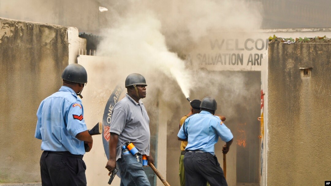 Polisi berpatroli sementara petugas pemadam kebakaran berusaha memadamkan api di gereja Salvation Army sesudah gereja tersebut dibakar oleh perusuh di Mombasa, Kenya, 4/10/2013. 