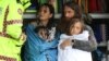 A family receives medical attention after being by the Marine Rescue boat as the state of New South Wales experiences widespread flooding and severe weather, in the suburb of Sackville North in Sydney, Australia.