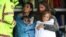 A family receives medical attention after being by the Marine Rescue boat as the state of New South Wales experiences widespread flooding and severe weather, in the suburb of Sackville North in Sydney, Australia.