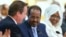 Britain's Prime Minister David Cameron, left, and Somali President Hassan Sheikh Mohamud, center, shake hands after opening speeches, London, May 7, 2013.