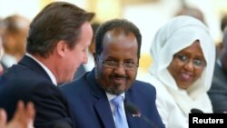 Britain's Prime Minister David Cameron, left, and Somali President Hassan Sheikh Mohamud, center, shake hands after opening speeches, London, May 7, 2013.
