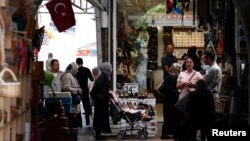 People shop in a shopping district in Hatay, Turkey, May 17, 2013. 