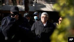 Golden Dawn party leader Nikos Michaloliakos, center, leaves his residence in Athens, Greece, Oct. 22, 2020.