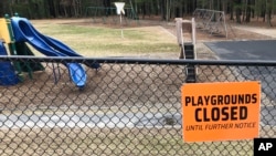 FILE - This March 20, 2020 file photo shows a closed sign near an entrance to a playground at an elementary school in Walpole, Mass., amid the COVID-19 outbreak.