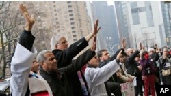 Clergy members and other supporters of the New Sanctuary Coalition pray in front of the Trump International Hotel in New York, March 29, 2018. People gathered to show support for Aura Hernandez, an undocumented immigrant that has taken sanctuary in a church to prevent her from being deported and separated from her family.