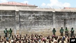 FILE - In this January 31, 2014 photo prisoners are closely guarded at Chikurubi Maximum Prison in Harare, Zimbabwe. This week, Zimbabwe has abolished the death penalty.