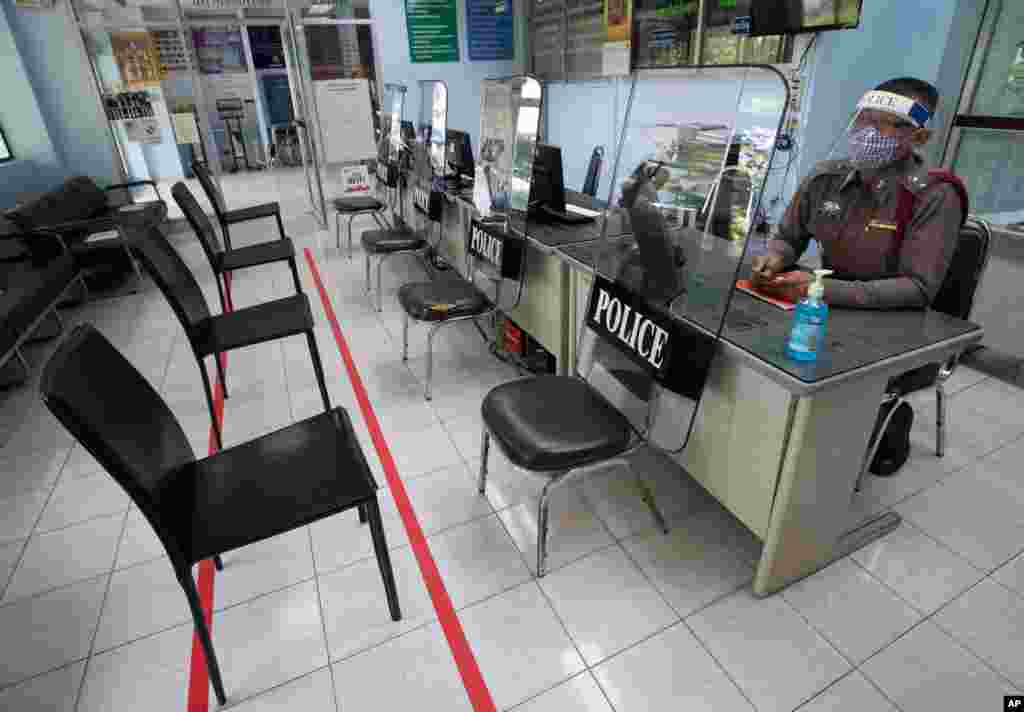 Police use riot shields to practice social distancing to help curb the spread of the coronavirus at the Tha Phra police station in Bangkok, Thailand.