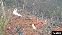 Para petugas mencari kotak hitam di lokasi jatuhnya pesawat China Eastern Airlines di Wuzhou, Guangxi, China, pada 22 Maret 2022. (Foto: Xinhua via Reuters/Zhou Hua)