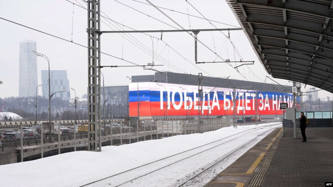 Slika snimljena 21. veljače 2024. prikazuje elektronički ekran na pročelju zgrade na kojem se nalazi ruska državna trobojnica i slogan "Pobjeda će biti naša!" u Moskvi. (Foto Natalia KOLESNIKOVA / AFP)