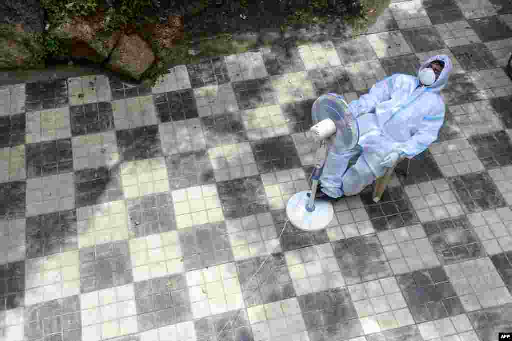 A health worker takes a break while sitting in front of a fan at a public health center in Hyderabad, India.