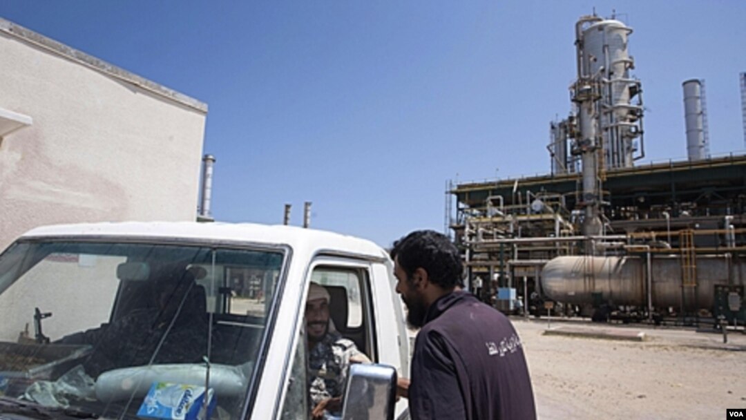 Pekerja Libya berbicara di dekat fasilitas penyulingan minyak Zawiya, dekat Tripoli. Uni Eropa akan menghapuskan sanksi minyak atas Libya, sehingga perusahaan minyak Libya akan bisa kembali beroperasi.