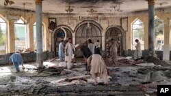 People view the damage inside of a mosque following a bombing in the provincial capital of Kunduz, northern Afghanistan, Oct. 8, 2021.