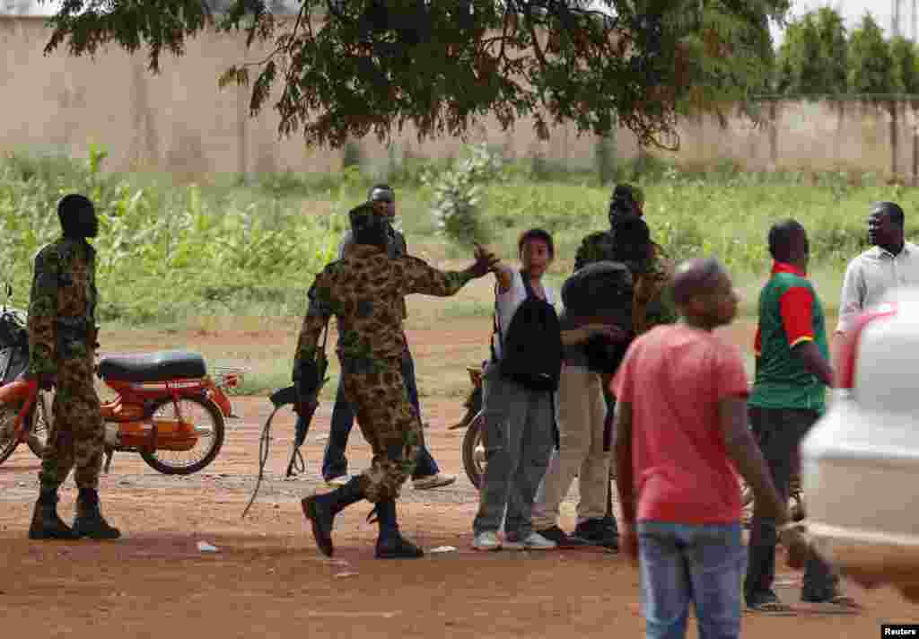 Presidential guard soldiers charge protesters and journalists at Laico hotel in Ouagadougou, Burkina Faso, September 20, 2015. Pro-coup demonstrators in Burkina Faso on Sunday invaded the hotel due to host talks aimed at hammering out the details of a dea