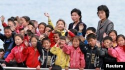 지난달 북한 접경 도시 신의주에서 압록강변으로 소풍나온 어린이들이 중국 쪽을 향해 손을 흔들고 있다.