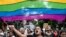 FILE - Activists and supporters of LGBTQ+ community wave the pride flag as they shout slogans in Kolkata, India, on Sept. 1, 2024. India's main opposition Congress party this week set up a new internal group to promote LGBTQ rights.