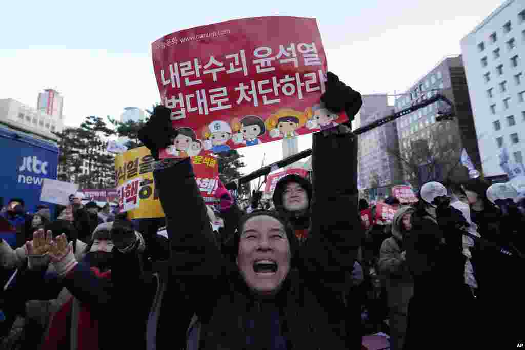 People celebrate after hearing the news that South Korea&#39;s parliament voted to impeach President Yoon Suk Yeol outside the National Assembly in Seoul, Dec. 14, 2024. The signs read &#39;Punish the rebellion leader Yoon Suk Yeol.&#39; Parliament has impeached Yoon over his martial law decree, a move that ended days of political paralysis but set up an intense debate over Yoon&rsquo;s fate.&nbsp;