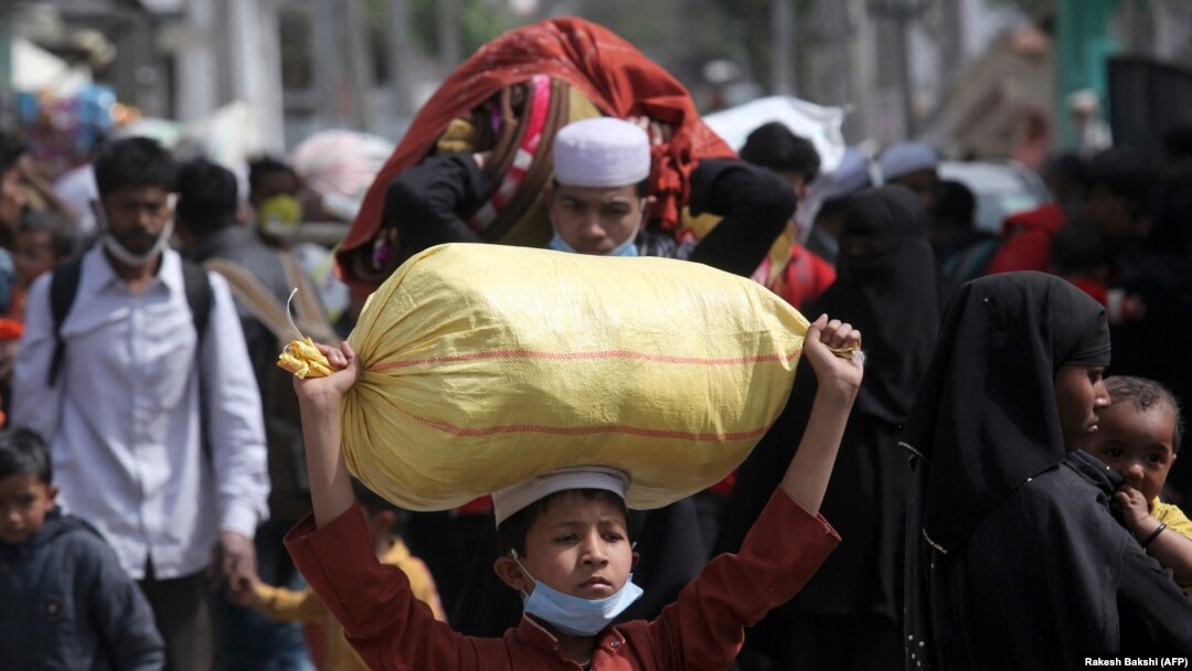 Para pengungsi Rohingya membawa barang-barang mereka meninggalkan kamp pengungsi di Jammu, Minggu, 7 Maret 2021. (Foto: Rakesh Bakshi/AFP)