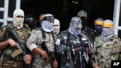 FILE - Masked Palestinian militants from Al Aqsa Martyrs' Brigade, a militia linked to the Fatah movement, give a press conference to condemn the decision by U.S. President Donald Trump to recognize Jerusalem as Israel's capital, in Gaza City, Dec. 7, 2017.
