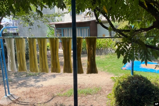 FILE - Cotton thread used for making the Japanese traditional craft of Sanuki Kagari Temari in Kawaramachi hang to dry in Kawaramachi, on Sept. 5, 2024. (AP Photo/Yuri Kageyama)