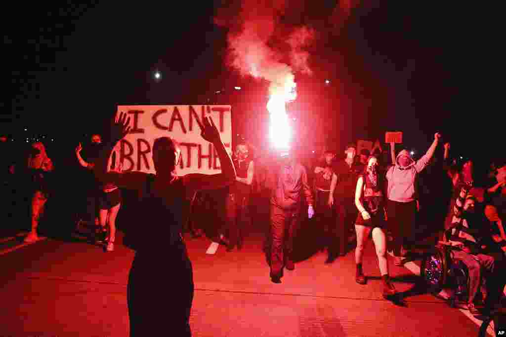 In this May 29, 2020, photo, Portlanders march with flares from the George Floyd vigil at Peninsula Park towards the Justice Center downtown in Portland, Oregon. Protests have been erupting all over…