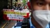 Pro-democracy protesters hold a banner during a demonstration against the election of Hong Kong's next chief executive on May 8, 2022. (Lam Yik/Reuters)